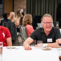 Man laughing with others at table